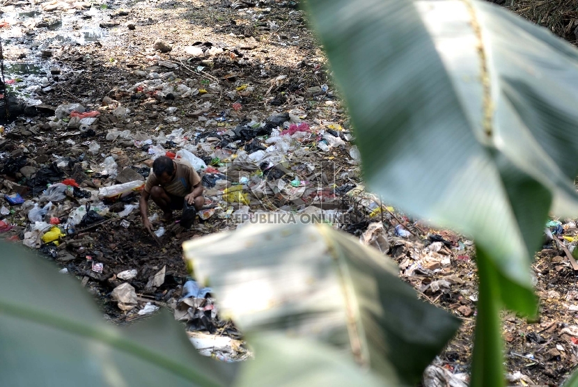 Pendangkalan Sungai. Warga mencari cacing tanah di tumpukan sampah di salah satu sungai yang dangkal di Jakarta, Rabu (8/7).