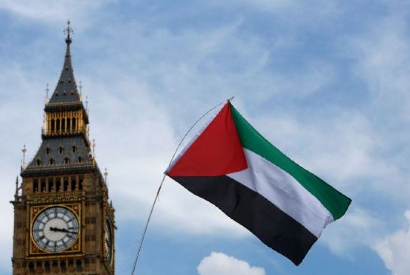 Pendemo mengibarkan bendera Palestina.