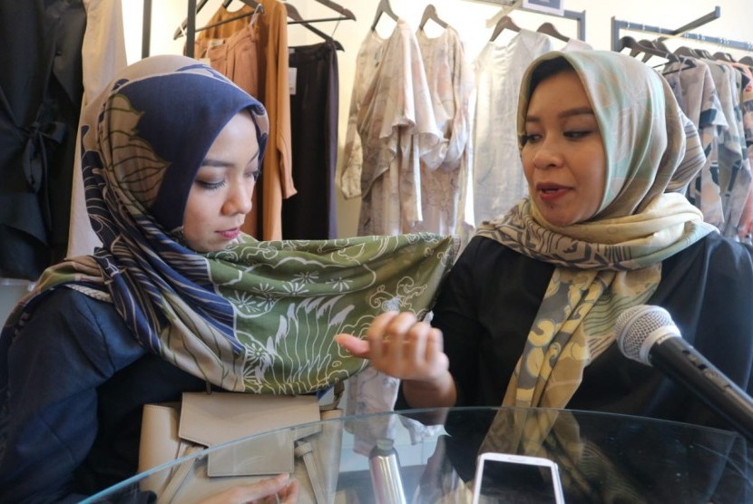 Pendiri Kamiidea, Istafiana Candarini (kanan) menunjukkan motif pattern jilbab koleksi Kamiidea, yang dikenakan pendiri Kamiidea yang lain, Afina Candarini (kiri). 