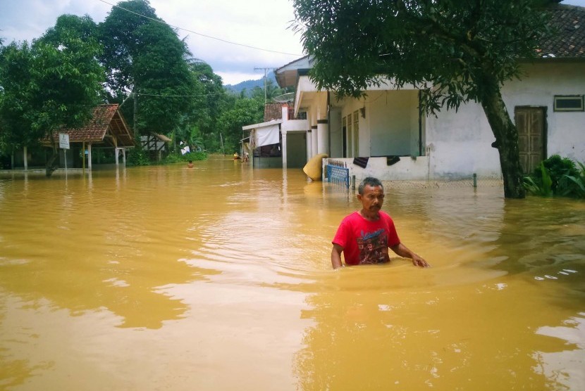 Penduduk berjalan digenangan banjir luapan Sungai Citanduy dan Cikidang, di Desa Tanjungsari, Kecamatan Sukaresik, Kabupaten Tasikmalaya, Kamis (17/3). Banjir mengakibatkan sedikitnya 500 rumah terendam.