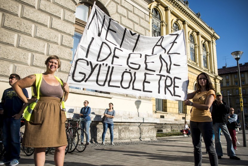 Penduduk Hungaria berunjuk rasa mendukung masuknya migran di stasiun kereta Keleti, di Budapest, (12/9). Mereka membawa spanduk bertuliskan 