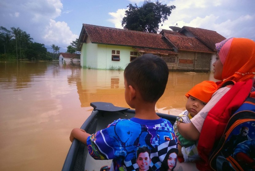 Penduduk mengarungi banjir luapan Sungai Citanduy dan Cikidang, di Desa Tanjungsari, Kecamatan Sukaresik, Kabupaten Tasikmalaya, Kamis (17/3). Banjir mengakibatkan sedikitnya 500 rumah terendam.