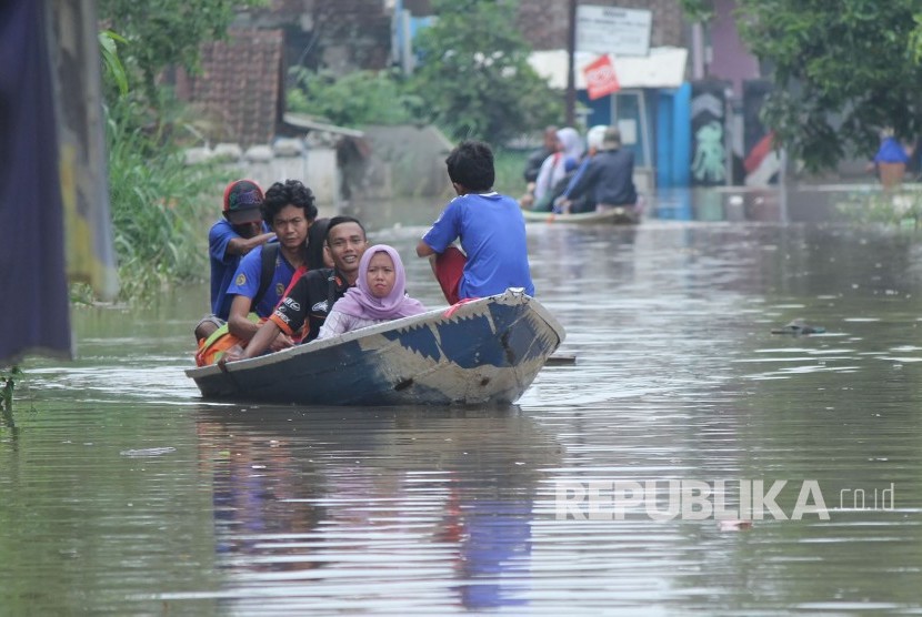 Penduduk menggunakan jasa perahu untuk melalui jalan yang sudah terendam banjir luapan Sungai Citarum di Jalan Raya Katapang Andir, Kecamatan Baleendah, Kabupaten Bandung, Rabu (15/11). 