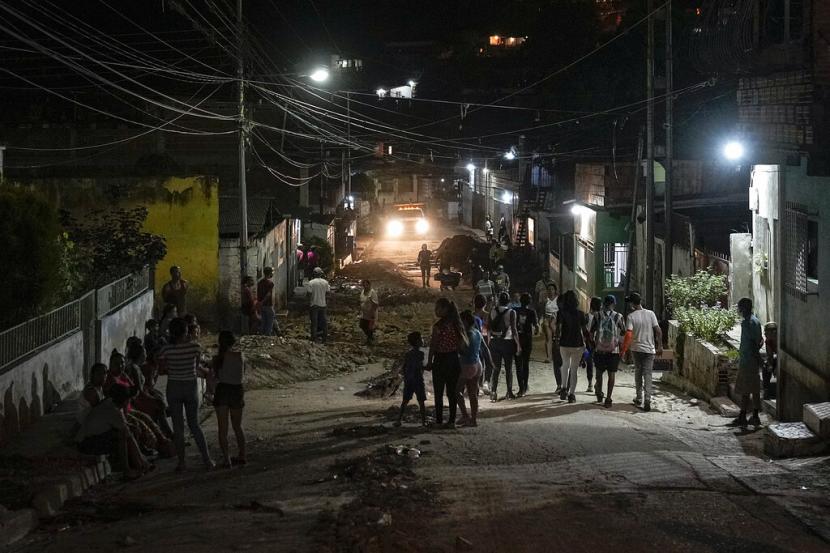 Penduduk setempat berjalan di jalan setelah tanah longsor melanda Las Tejerias, Venezuela, Selasa, 11 Oktober 2022. Tim penyelamat bekerja untuk membersihkan batu dan lumpur dari jalan-jalan, tiga hari setelah tanah longsor besar dan mematikan, dan memperluas pencarian mereka untuk mencari mayat. terkubur di bawah lumpur.