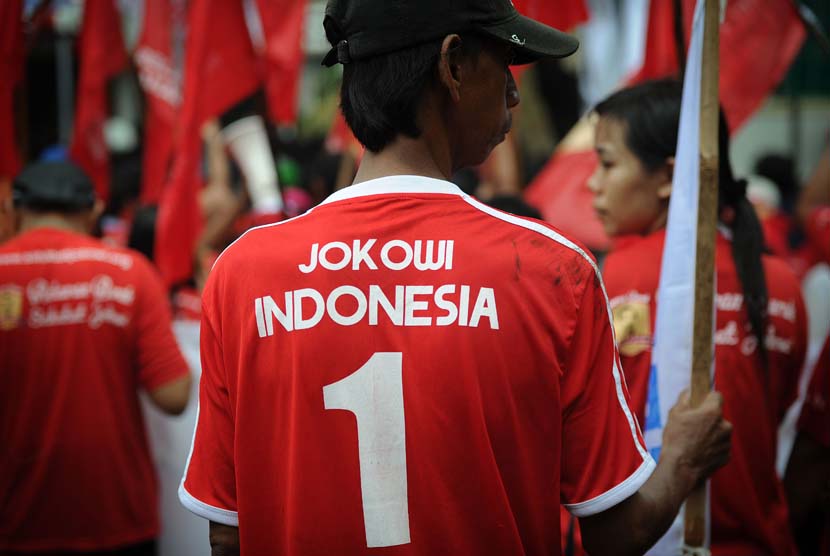 Pendukung Calon Presiden dan Calon Wakil Presiden dari PDIP Joko Widodo - Jusuf Kalla, membawa bendera di Gedung KPU, Jakarta, Senin (19/5). 