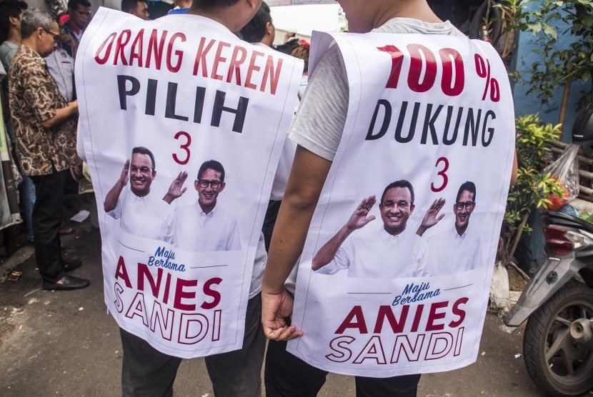 Pendukung Calon Wakil Gubernur DKI Jakarta Sandiaga S. Uno memakai atribut kampanye di Johar Baru, Jakarta, Kamis (10/11). 