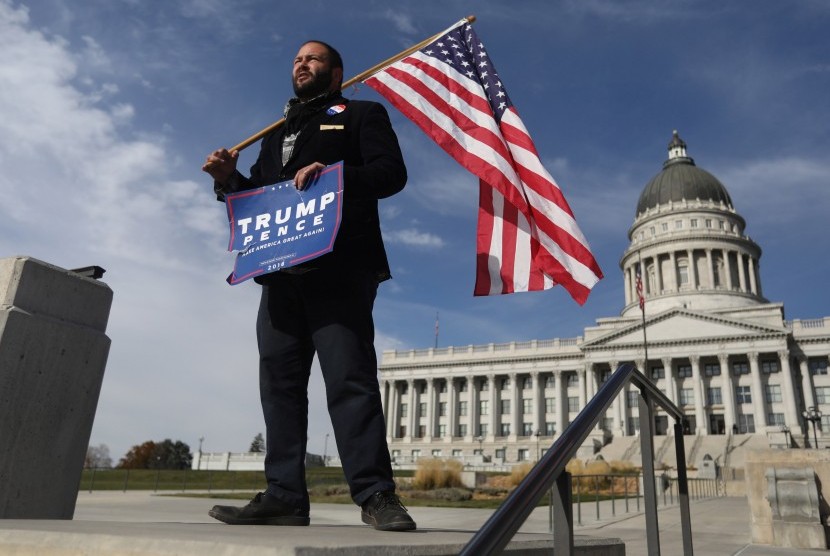  Pendukung Donald Trump, Kern Carlos Huerta, di Utah, (12/11), menanti demonstran yang akan memprotes hasil pilpres AS yang menempatkan Trump sebagai presiden AS.