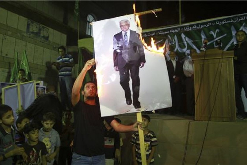   Pendukung Hamas membakar poster gambar Presiden Palestina, Mahmoud Abbas, dalam aksi demonstrasi di Jabalya, Gaza, Palestina, Sabtu (3/11). 