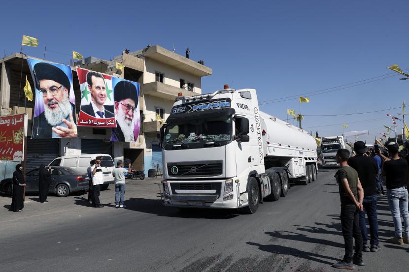 Pendukung Hizbullah merayakan ketika konvoi truk tanker yang membawa diesel Iran melintasi perbatasan dari Suriah ke Lebanon, tiba di kota timur el-Ain, Lebanon, Kamis, 16 September 2021.
