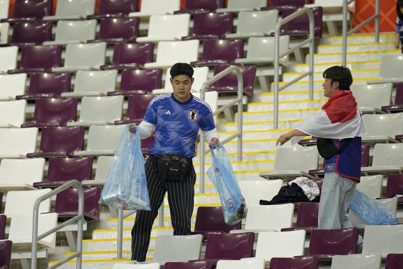 Suporter Jepang memungut sampah di tribun penonton usai pertandingan Grup E antara Jepang dengan Spanyol di Stadion Internasional Khalifa, Doha, Qatar, Jumat (2/12/2022). 