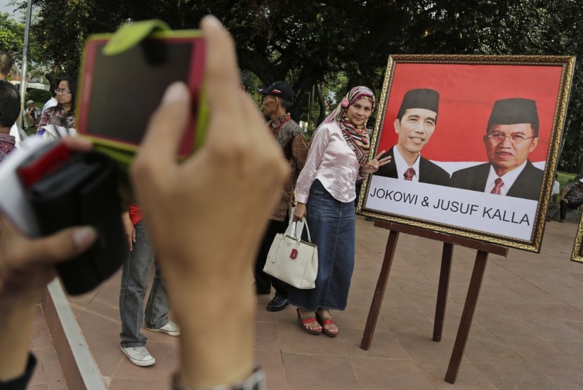 Pendukung Jokowi-JK berfoto dengan gambar pasangan capres nomor urut dua di Jakarta