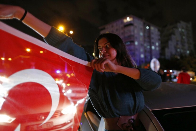 Pendukung kandidat wali kota Istanbul dari partai oposisi Turki Republican People's Party's (CHP), Ekrem Imamoglu, memegang bendera Turki di Istanbul, Senin (6/5).