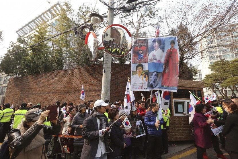 Pendukung mantan Presiden Park Geun-hye menunggu kedatangannya di depan rumah pribadinya di Seoul, Korsel, (12/3).