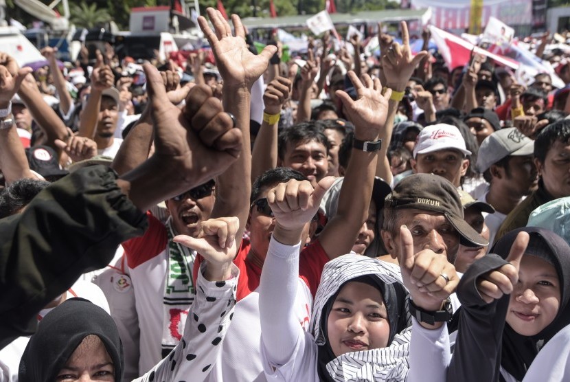 Pendukung pasangan Capres dan Cawapres nomor urut 01, Joko Widodo (Jokowi)-Ma'ruf Amin, berjalan menuju lokasi Konser Putih Bersatu sebagai rangkaian kampanye akbar pasangan capres-cawapres tersebut di Gelora Bung Karno (GBK), Jakarta, Sabtu (13/4).
