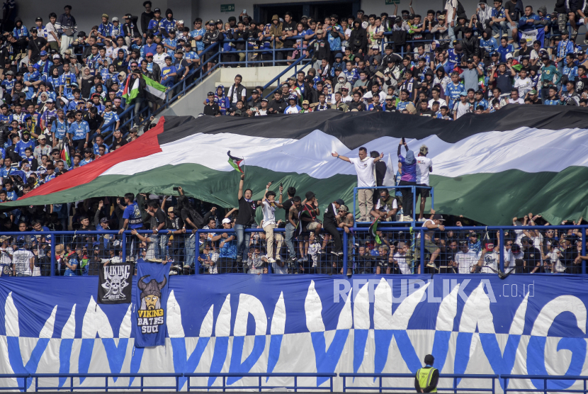 Pendukung Persib Bandung atau bobotoh mengibarkan bendera Palestina saat pertandingan lanjutan BRI Liga 1 2023-2024 antara Persib Bandung melawan Arema FC di Stadion Gelora Bandung Lautan Api (GBLA), Gedebage, Kota Bandung, Jawa Barat, Rabu (8/11/2023). Aksi tersebut merupakan bentuk solidaritas dan dukungan kepada rakyat Palestina. Selain itu, mereka mendesak pemberhentian genosida yang dilakukan Israel terhadap rakyat Palestina.