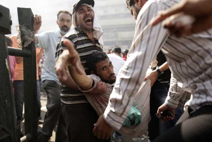 Pendukung Presiden Muhammad Mursi mengevakuasi orang terluka dalam bentrokan dengan pasukan keamanan Mesir di Ramses Square, Kairo, Mesir, Jumat (16/8).