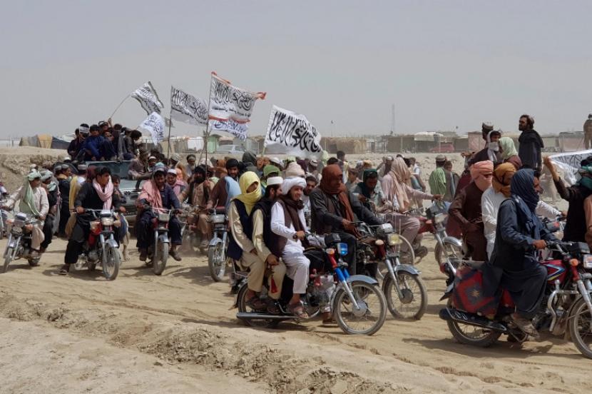 Pendukung Taliban membawa bendera putih tanda tangan mereka setelah mereka merebut kota perbatasan Afghanistan, Spin Boldak