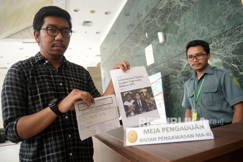 Peneliti ICW Kurnia Ramadhana mewakili Koalisi Masyarakat Sipil Antikorupsi menunjjukan tanda terima usai melakukan pelaporan kepada Badan Pengawasan Mahkamah Agung di Jakarta, Kamis (5/10). 