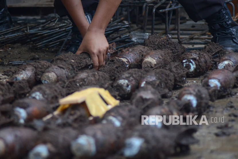 Penemuan Mortir. Petugas menata sejumlah mortir yang telah diambil dari dalam tanah di rumah warga di Gang Cinta Wangi, Dago, Bandung, Jawa Barat, Selasa (5/3/2019).