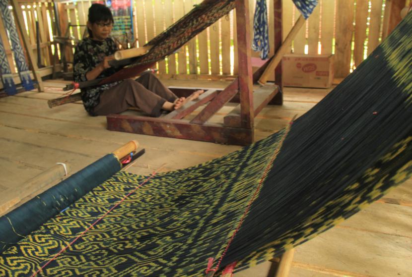 Penenun menyelesaikan pembuatan kain tenun sekomandi di salah satu industri rumahan Desa Bambu, Kecamatan Mamuju, Kabupaten Mamuju, Sulawesi Barat, Sabtu (13/6/2020). 