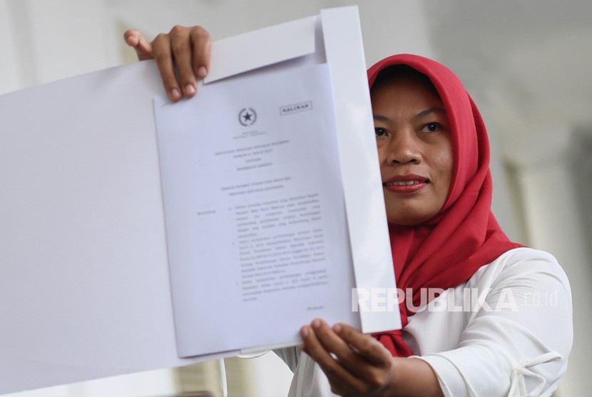 Penerima amnesti dari presiden, Baiq Nuril Maknun membawa salinan petikan keppres amnesti usai bertemu dengan Presiden Joko Widodo di Istana Bogor, Jawa Barat, Jumat (2/8/2019). 