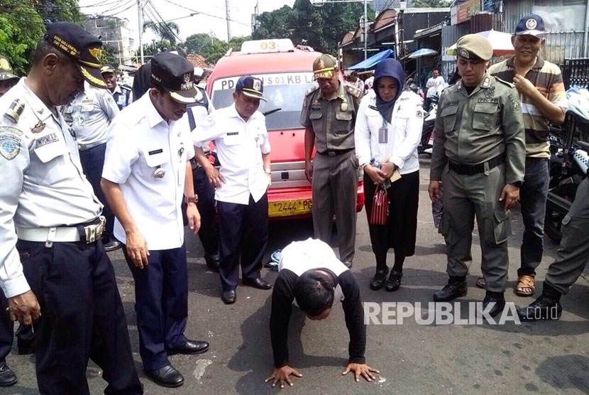 Penertiban parkir liar, seorang sopir angkot, Soni, mendapatkan hukuman push up lantaran tidak mengenakan seragam, Rabu (5/7). 