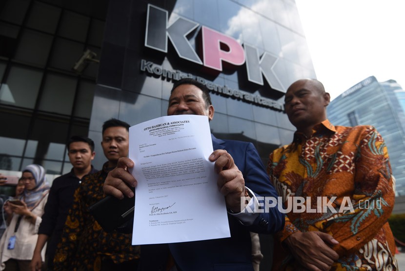 Pengacara Otto Hasibuan (kedua kanan) memperlihatkan surat pengunduran dirinya sebagai kuasa hukum tersangka kasus korupsi KTP Elektronik Setya Novanto saat tiba di gedung KPK, Jakarta, Jumat (8/12).