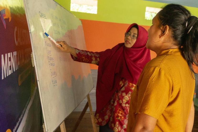 Pengajar memberikan arahan dalam program Calistung di Kelurahan Mentaya sebagai upaya meningkatkan taraf hidup warga di sekitar konservasi hutan gambut. 