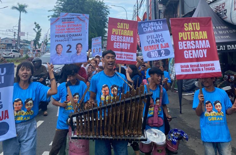 Pengamen angklung pendukung Prabowo-Gibran menyosialisasikan pemilu damai di Jakarta, Ahad (28/1/2024).