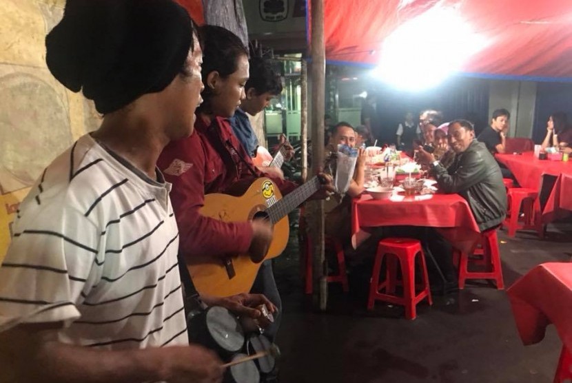 Pengamen menyanyikan lagu hits Ahmad  Dhani dan Dewa di kedia Dudung, Jakarta pusat, (21/1).