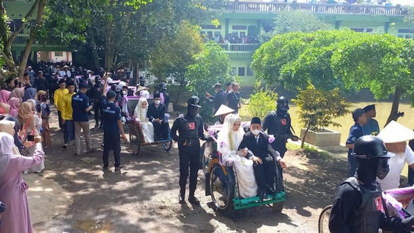 Pengantin menaiki becak untuk diarak keliling jalan desa saat pernikahan massal santri di Pesantren Miftahul Huda 2 Bayasari, Kecamatan Jatinagara, Kabupaten Ciamis, Jawa Barat, Senin (23/1/20223). 
