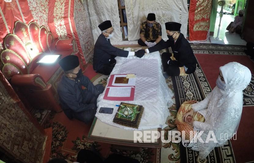 Pengantin pria menggunakan masker mengucapkan kalimat ijab-kabul saat prosesi pernikahan. Kemenag Belitung tunda pendaftaran nikah untuk cegah meluasnya Covid-19. Ilustrasi.
