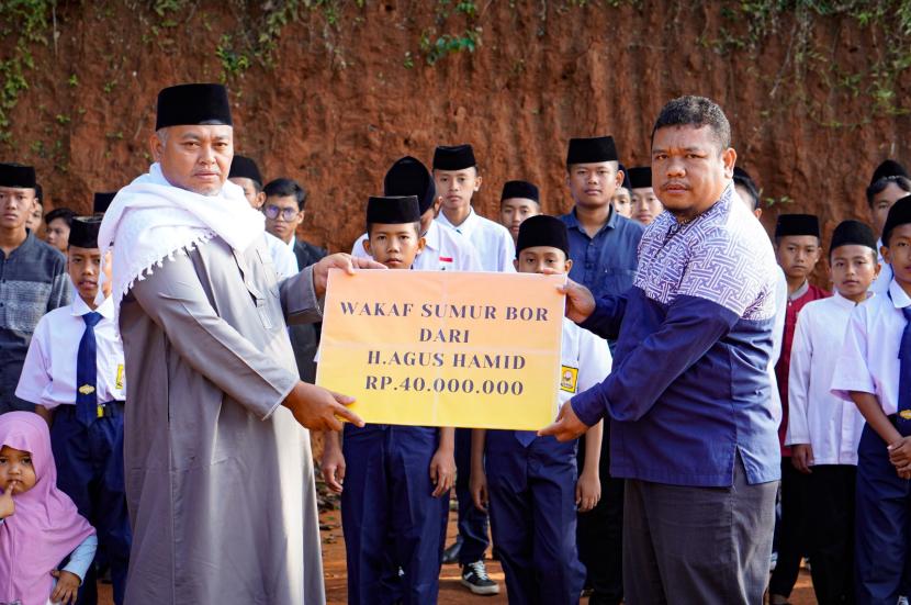 Pengasuh Pesantren Darul Falah Cimenteng Kiai Komaruddin menerima wakaf dari Direktur Dafa Peduli Asep Hendra.