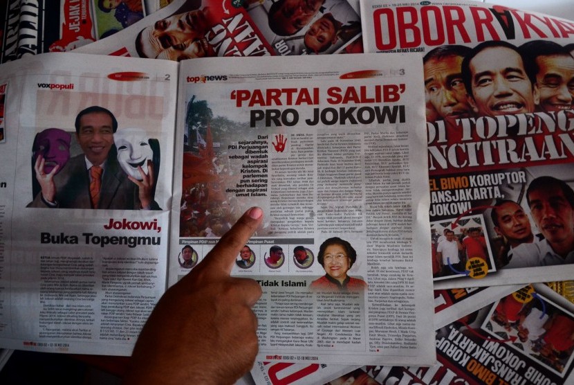 Pengasuh Pondok Pesantren Al Munawaroh, Muhtar Hudori menunjukkan tabloid Obor Rakyat edisi terbaru di Kelurahan Sumur Panggang, Tegal, Jateng, Ahad (6/7).