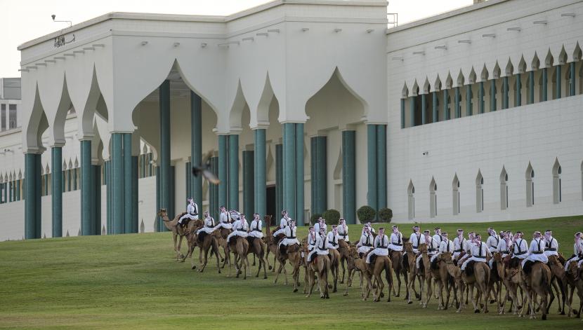 Masjid Qatar Menampilkan Pusat Atraksi bagi Penggemar Piala Dunia. Foto: Pengawal kerajaan berpatroli di atas unta di depan masjid dekat Parlemen Qatar pada hari sebelum dimulainya Piala Dunia Sepak Bola di Doha, Qatar, Sabtu, 19 November 2022. 