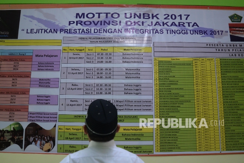 Pengawas melihat jadwal Ujian Nasional Berbasis Komputer (UNBK) di MAN 4 Jakarta, Selasa (11/4). 