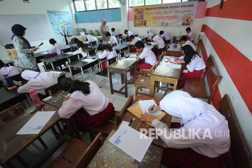 Kementerian Pendidikan dan Kebudayaan diminta mengkaji terlebih dahulu sistem yang akan menggantikan UN. Foto: Pengawas membagikan soal saat Ujian Sekolah Berstandar Nasional (USBN), di SDN 062 Ciujung, Jalan Supratman, Kota Bandung, Senin (22/4).