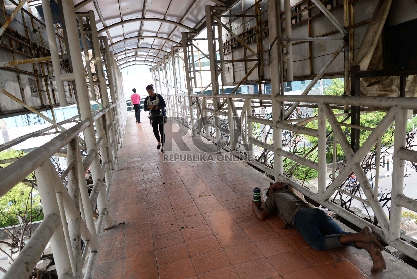 Pengemis tidur di Jembatan Penyeberangan Orang (JPO) di Jalan Rasuna Said, Jakarta.