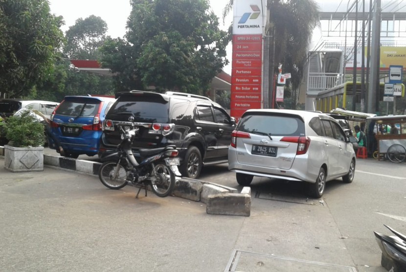 Pengemudi angkutan online memarkir mobilnya di pinggir Jalan Casablanca, Jakarta Selatan, Rabu (1/8). Para supir itu mengeluh pemberlakuan perluasan sistem ganjil-genap mengakibatkan penghasilannya menurun.