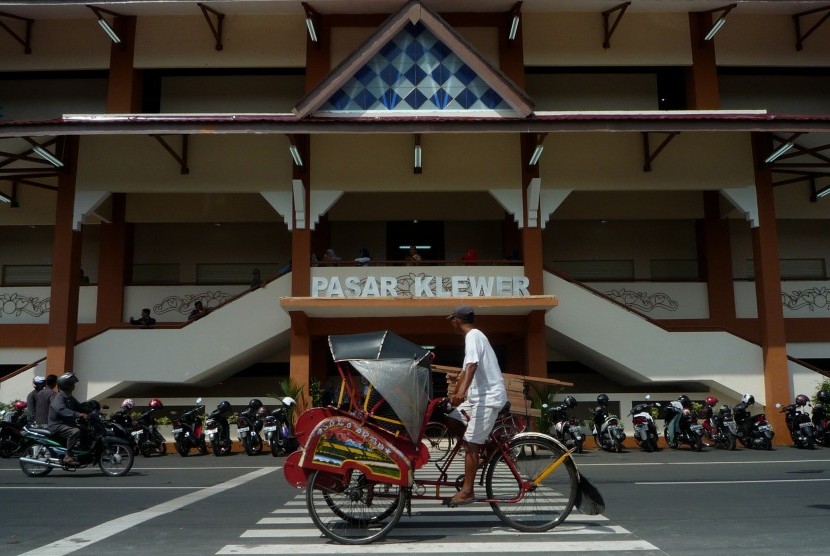 Pengemudi becak melintas di depan bangunan baru Pasar Klewer sisi barat di Solo, Jawa Tengah, Minggu (23/4). 