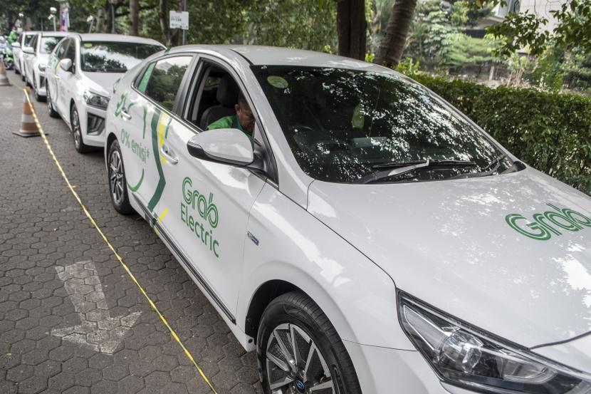Pengemudi kendaraan listrik GrabElectric menunggu calon pengguna di Jakarta, Selasa (12/7/2022). Dalam rangka mengurangi emisi karbon dan menghemat konsumsi bahan bakar minyak, pemerintah menargetkan 6 juta kendaraan listrik mengaspal di Indonesia hingga 2025.