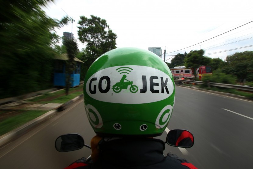  Pengemudi ojek berbasis online mengantar penumpang di kawasan Palmerah, Jakarta, Jumat (18/12). 