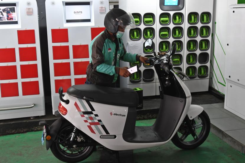 Pengemudi ojek daring mengganti baterai sepeda motor listriknya di stasiun pengisian baterai listrik di Kuningan, Jakarta, Senin (30/5/2022). Berdasarkan data Kementerian Perhubungan per Maret 2022, jumlah kendaraan bermotor listrik berbasis baterai (KBLBB) di Indonesia mencapai 16.060 unit atau naik 74 persen dari jumlah pada Agustus 2021 yang mencapai 9.192 unit, sementara jumlah stasiun pengisian baterai listrik per Februari 2022 mencapai 267 unit di 195 titik se-Indonesia. 