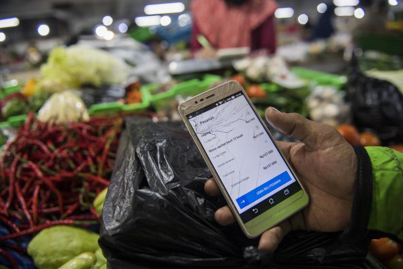 ilustrasi. Pengemudi ojek menunjukan pesanan belanja daring di pasar Kosambi, Bandung, Jawa Barat, Jumat (10/4/2020). Layanan belanja online dan siap antar tersebut bertujuan untuk membatasi lalu lalang orang di pasar dan juga sebagai upaya pencegahan penyebaran COVID-19.