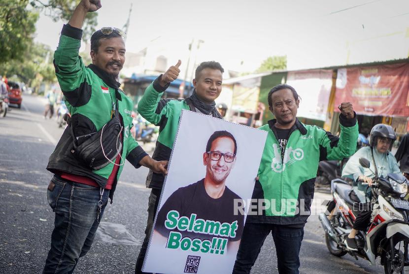 Pengemudi ojek online Gojek membawa poster ucapan selamat kepada Pendiri dan CEO Gojek Nadiem Makarim di Solo, Jawa Tengah, Rabu (23/10/2019).