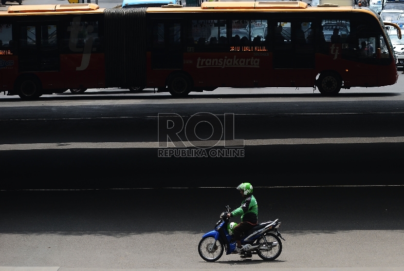  Pengemudi ojek online melintasi Jalan Rasuna Said, Jakarta Selatan, Jumat (18/12).  (Republika/Raisan Al Farisi)