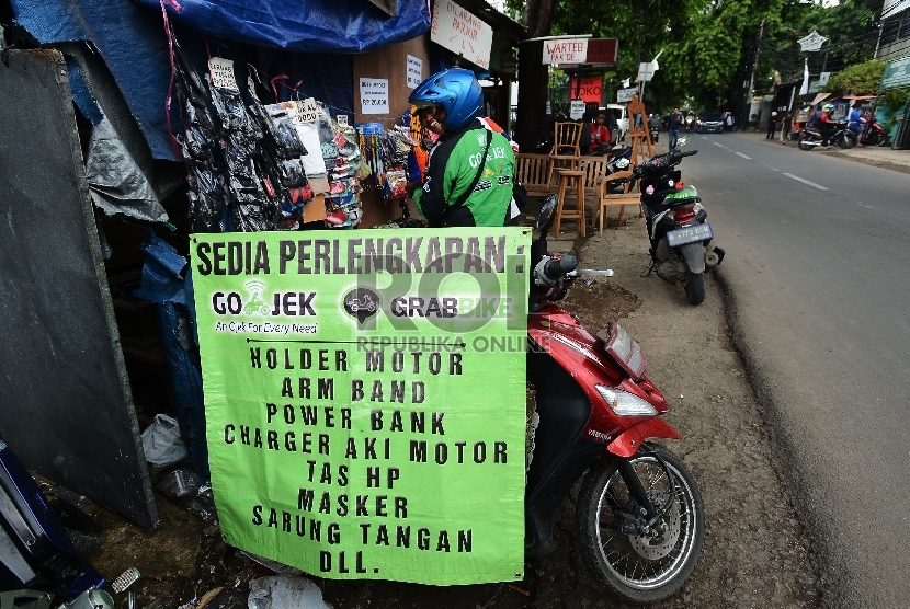  Pengemudi ojek online membeli perlengkapannya di Jalan Kemang Timur, Jakarta, Jumat (18/12). (Republika/Raisan Al Farisi)