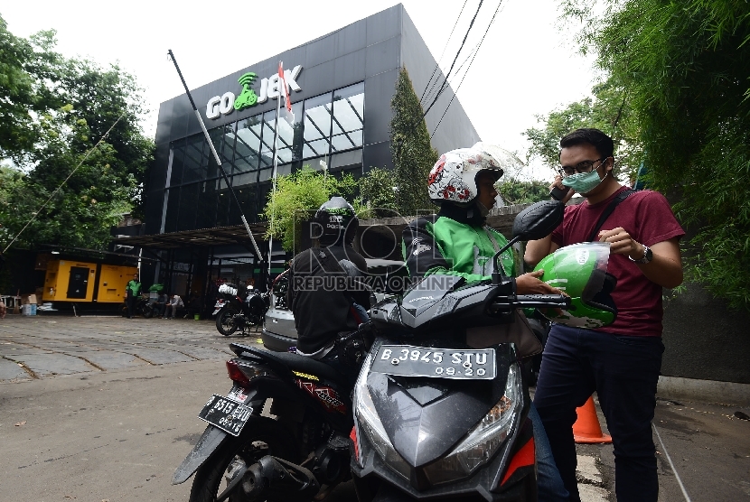  Pengemudi ojek online mengangkut penumpang di Jalan Kemang Selatan, Jakarta, Jumat (18/12). 