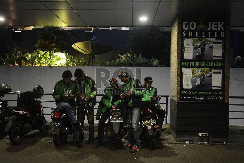   Pengemudi ojek online menunggu penumpang di Kawasan Sudirman, Jakarta Selatan, Jumat (18/12). 