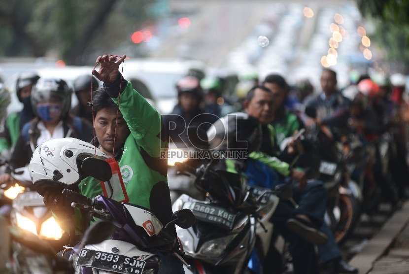  Pengemudi ojek online menunggu penumpang di Kawasan Kota Kasablanka, Jakarta Selatan, Jumat (18/12).